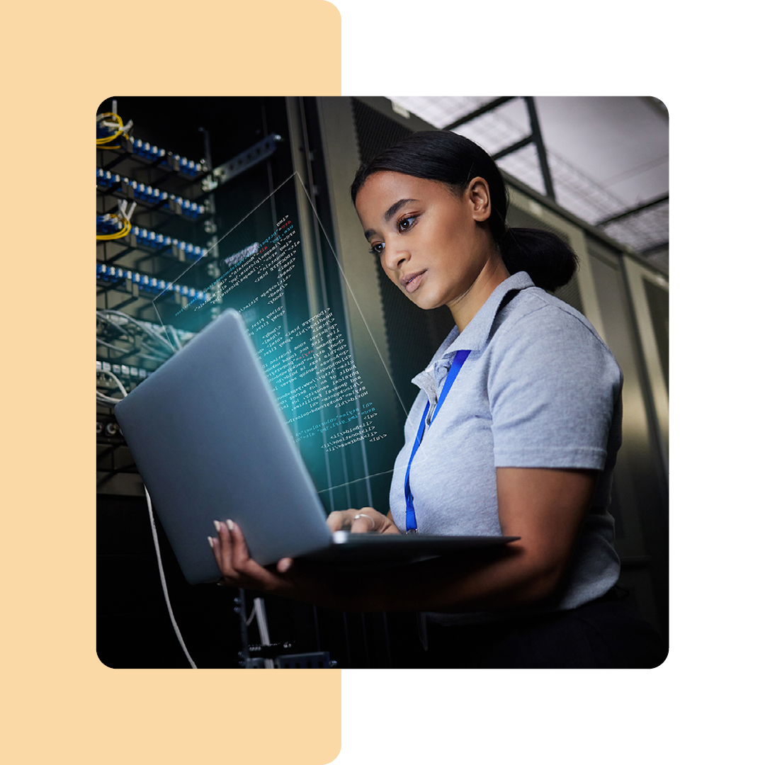 Image of an IT professional in a server room working on a laptop