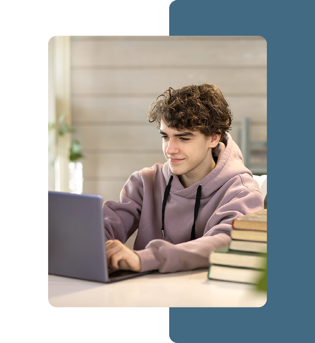 Image of a student working on a laptop in a classroom