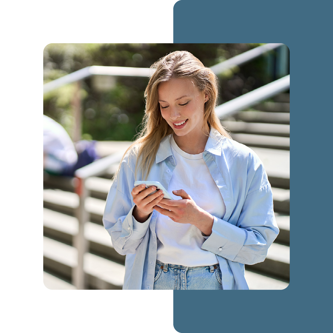 Image of a university student stood on a mobile phone on campus