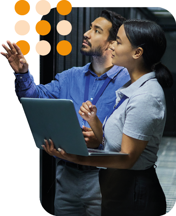 two people in a server room with a laptop discussing servers