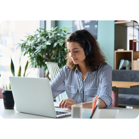 Person working at laptop with over ear headphones on