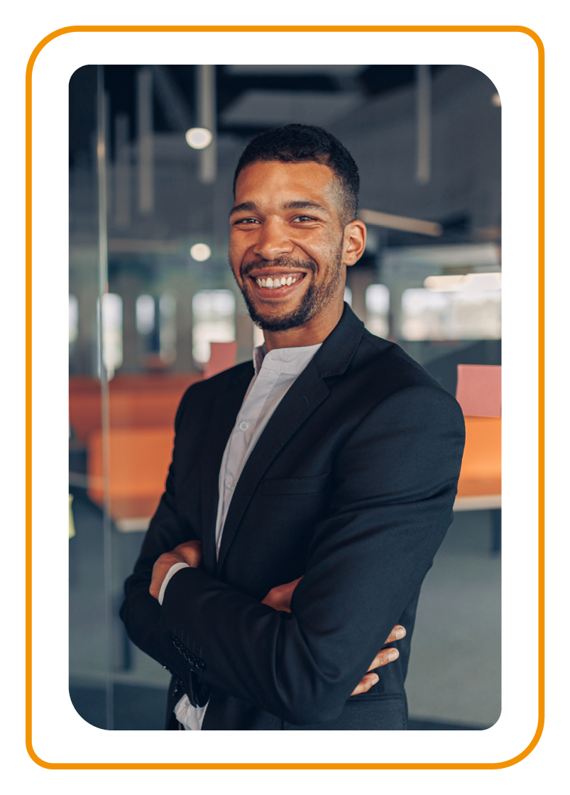 Portrait of smiling businessman standing in office with crossing arms