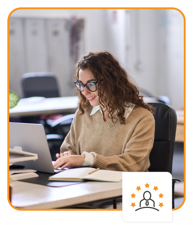 Smiling person working on laptop in modern office lobby space.