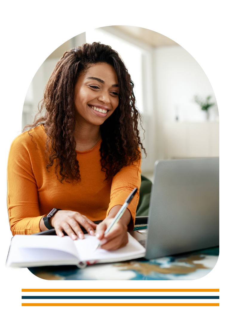 Portrait of student on a laptop making notes in a notebook