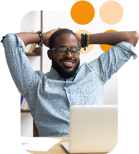 man relaxing at his desk with laptop open, arms behind his head